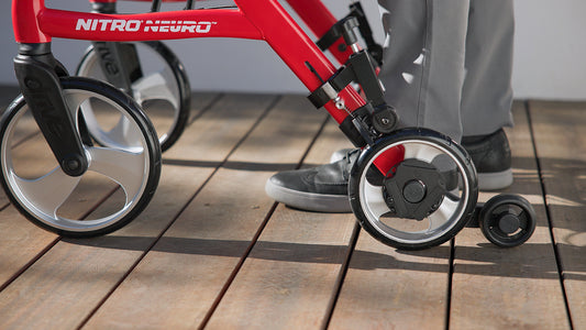 A closeup of a person's feet walking with a walker with walkwise attached to the rollator